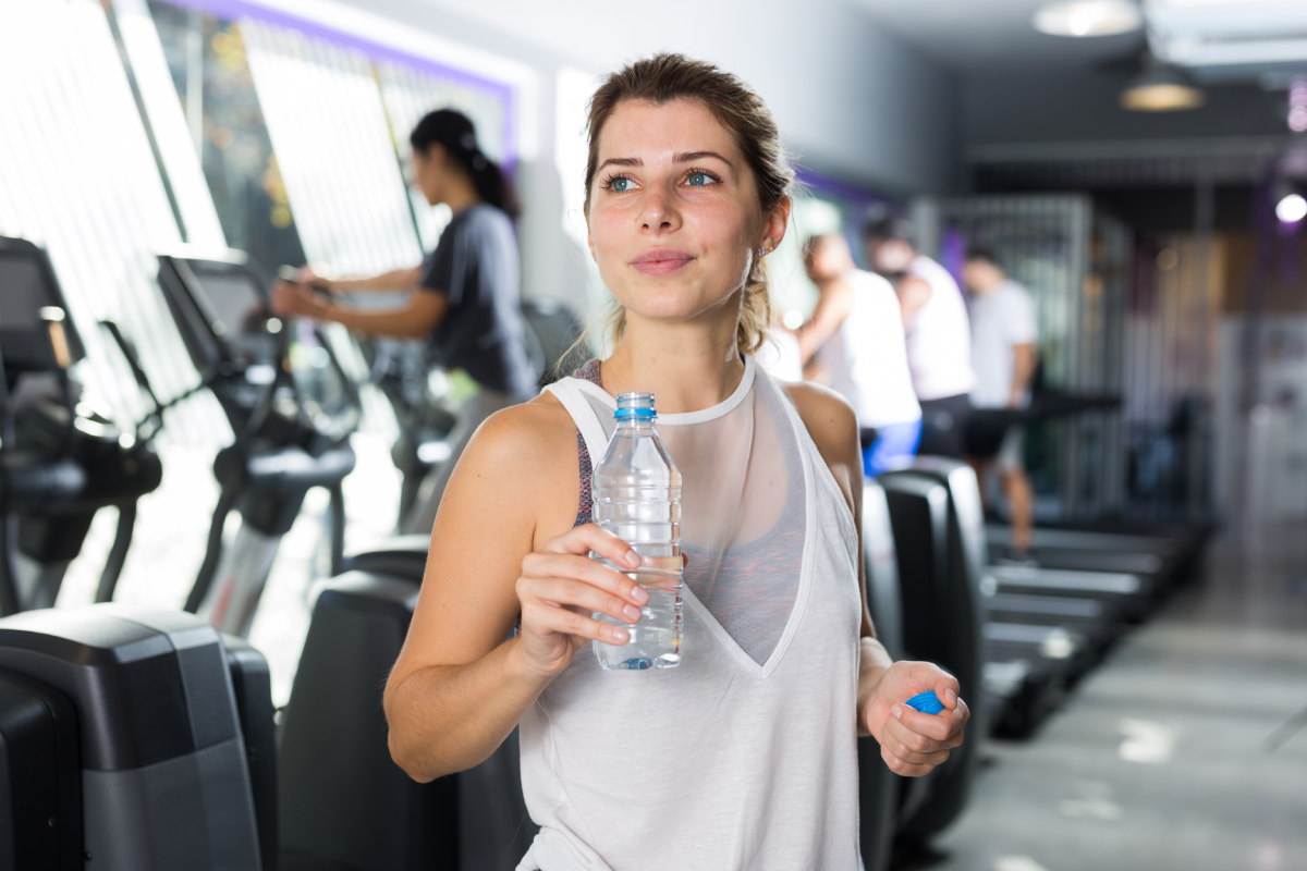 Womanin gym drinking bottled water